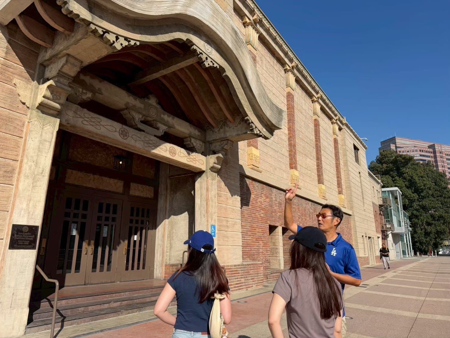 Guide Imai explaining the tour to guests in front of a historic building.