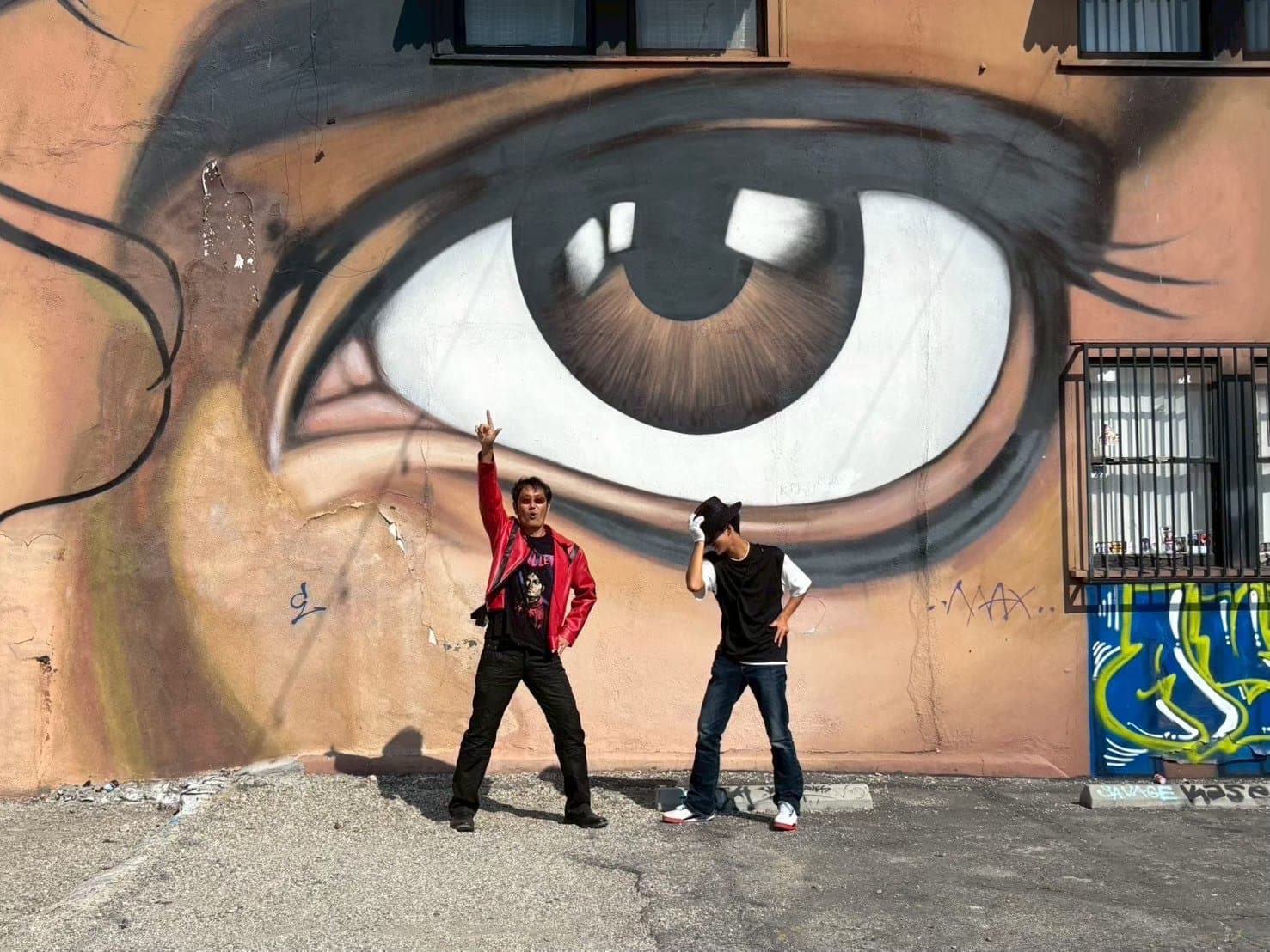 Posing in front of a large mural of eyes during the tour.